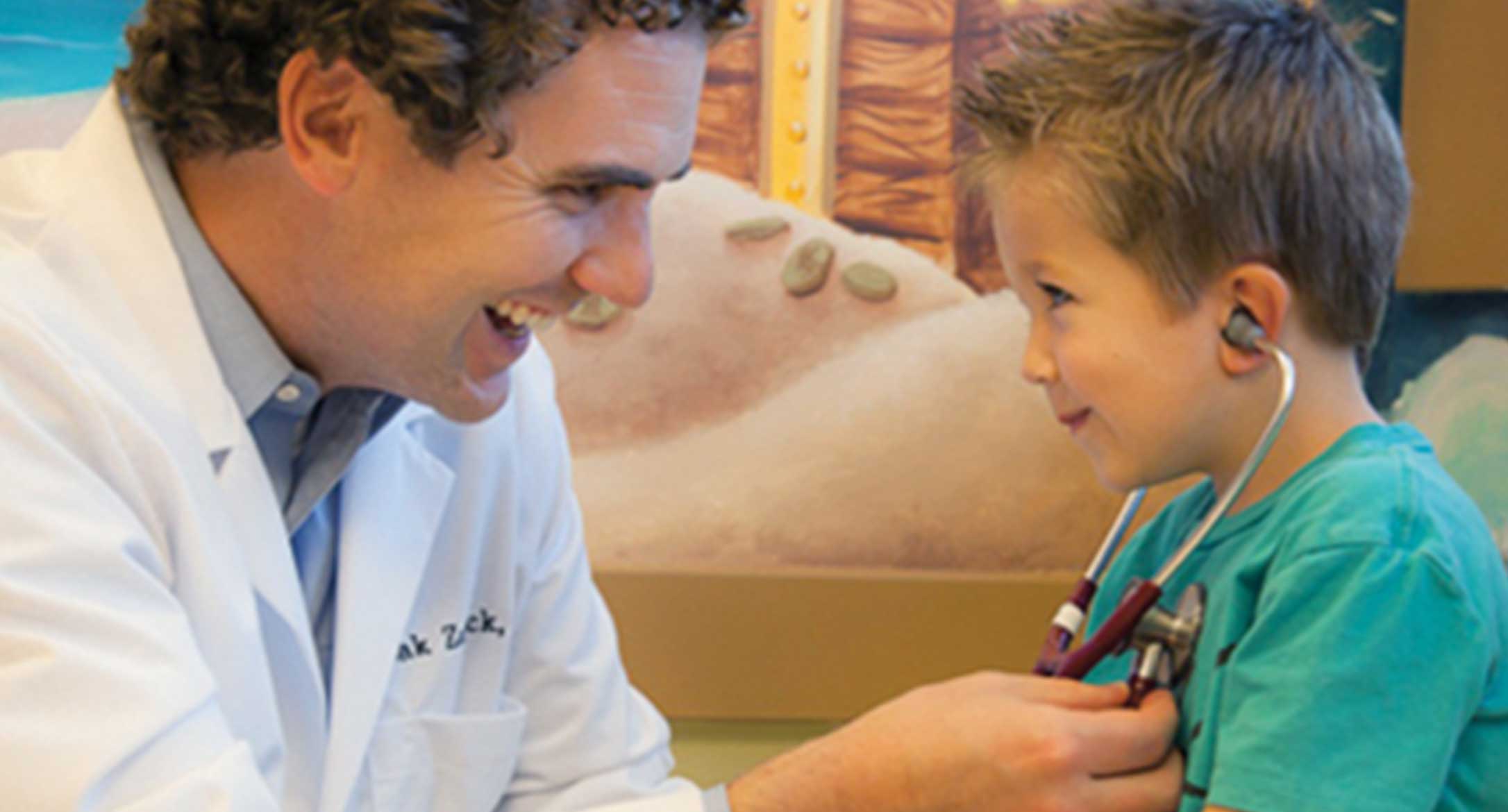 Pediatrician Dr. Zak Zarbock examining a child patient