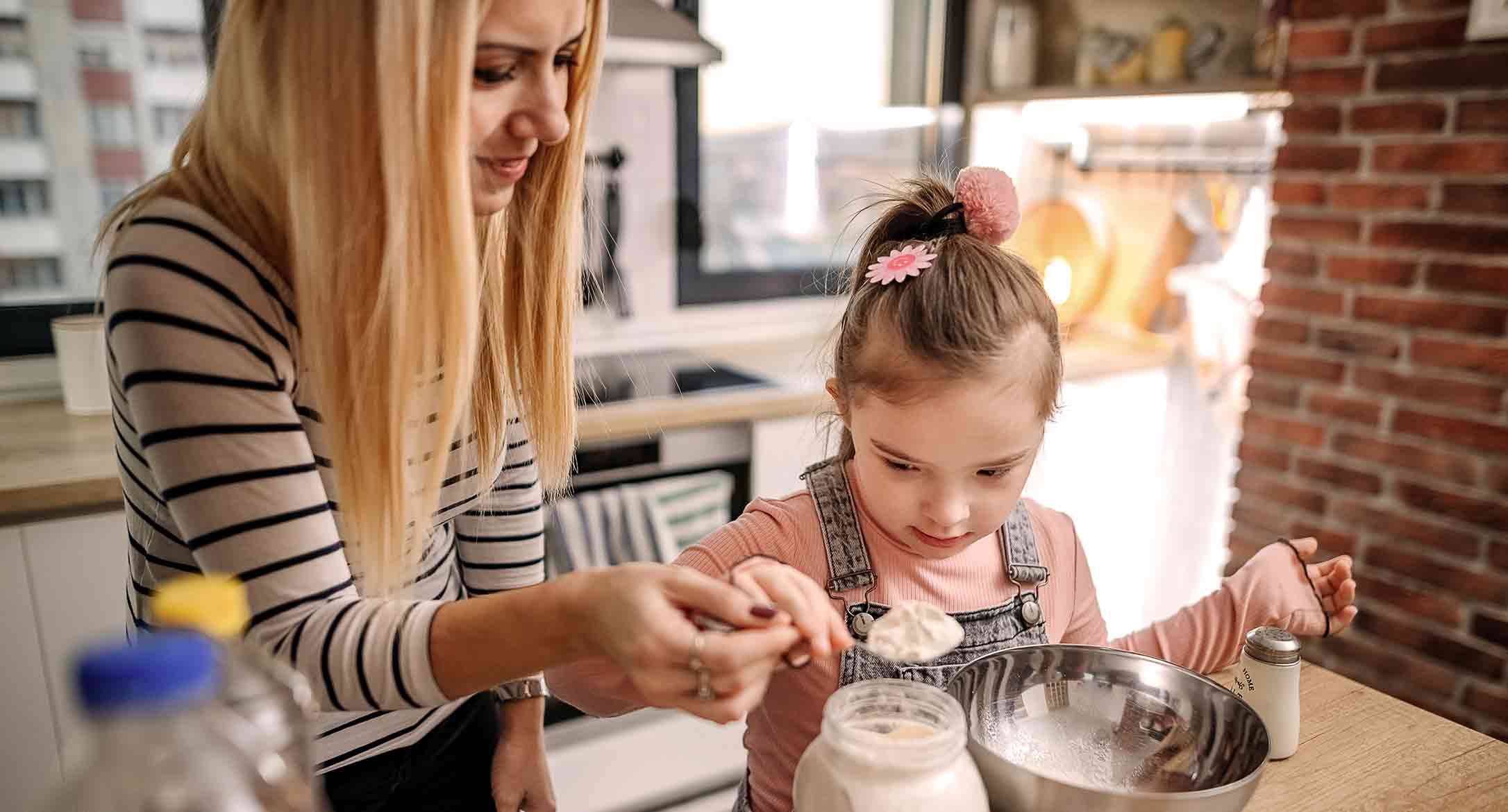 A daughter and her mom baking together in a kitchen